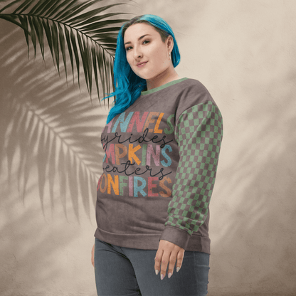 Person wearing an Espresso and sage green colorful sweatshirt with text and pattern, standing against a beige wall with a palm leaf.