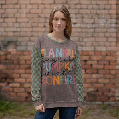 Woman wearing an Espresso and sage green sweatshirt with colorful text in front of a brick wall