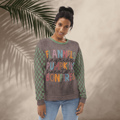 Woman wearing an Espresso and sage green sweater with colorful text against a beige wall with a leafy branch.