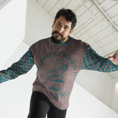 Man wearing an espresso and teal sweater with Frog reading with "Happiest When I'm Reading"  text design, standing indoors.