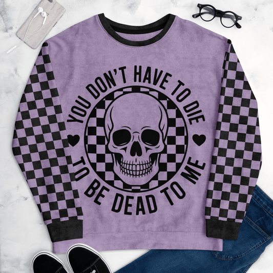Purple sweatshirt with skull design and text on a marble surface