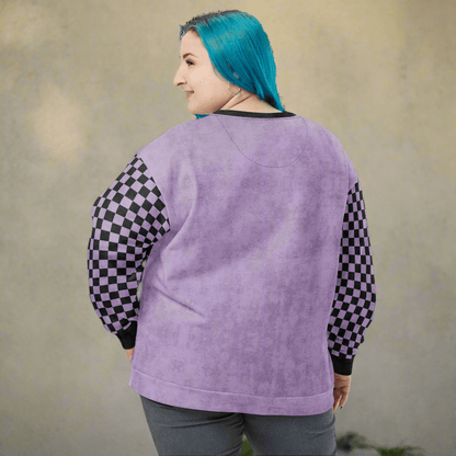Person wearing a purple sweatshirt with checkered sleeves against a beige background