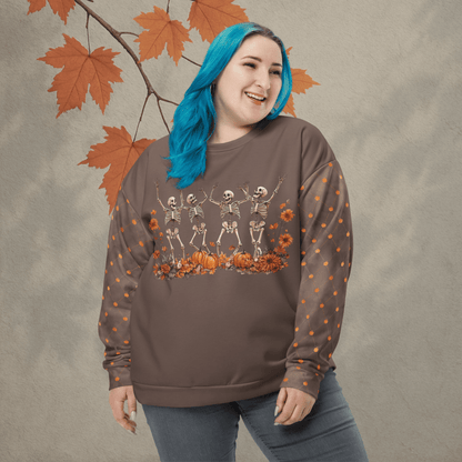Person wearing a brown sweatshirt with skeleton and pumpkin design, standing against a neutral background with autumn leaves.