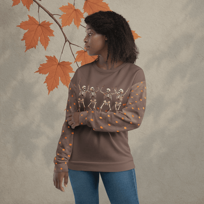 Woman wearing a brown sweatshirt with skeleton designs against an autumn leaf background