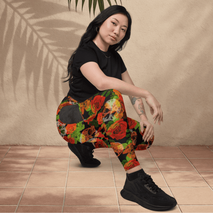 Person wearing colorful floral skull pants sitting on a tiled floor.