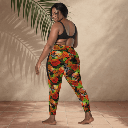 Woman wearing colorful floral sleggings with a beige wall and plant in the backgroundull 