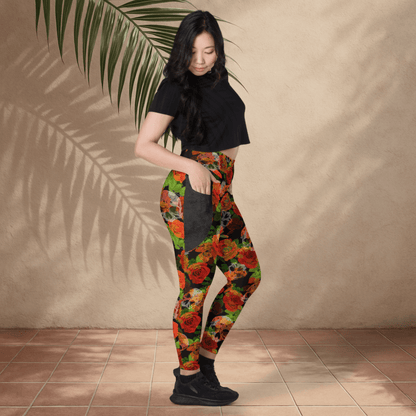 Woman wearing colorful floral skull leggings and a black top against a beige wall.