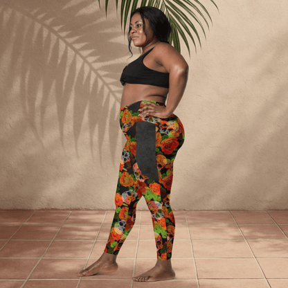 Woman wearing a black sports bra and colorful floral leggings with skulls against a beige wall.
