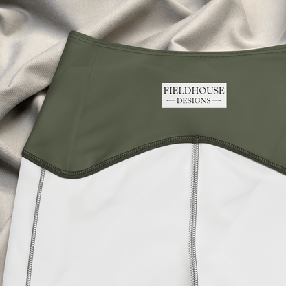 Close-up of a green waistband with 'Fieldhouse Designs' label on a gray fabric background