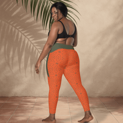 Person wearing orange patterned leggings and black sports bra against a beige wall.