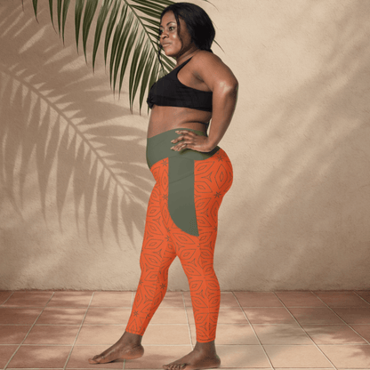 Woman wearing orange and green patterned leggings against a beige wall.