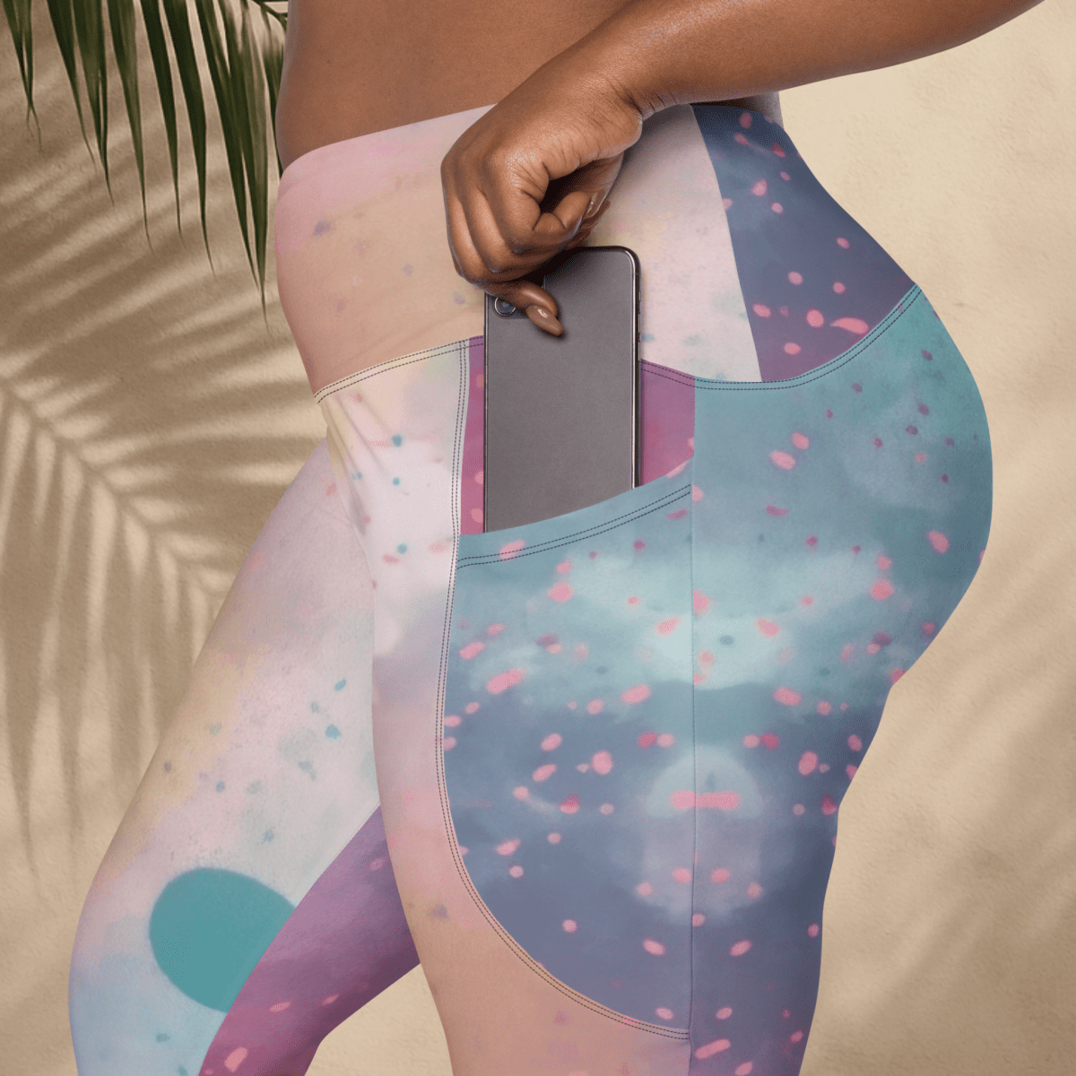 Colorful patterned leggings with a pocket holding a phone, against a neutral background.