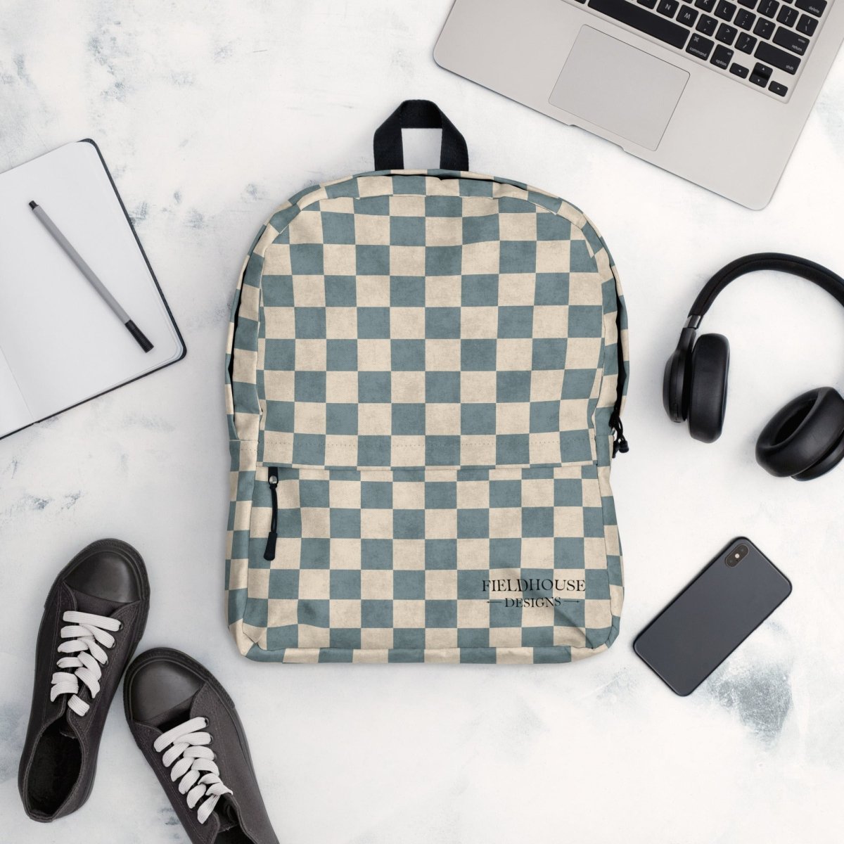Dusty Blue and cream Checkered backpack on a marble surface with a laptop, headphones, and shoes.