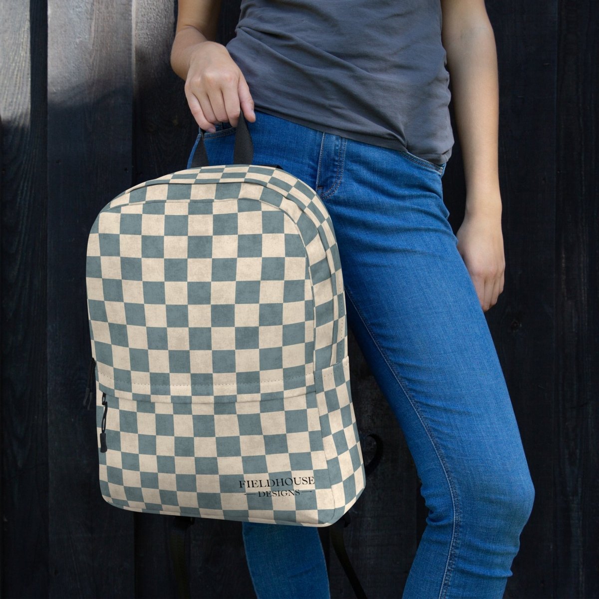 Person wearing a checkered backpack with 'Fieldhouse Designs' branding on a dark background