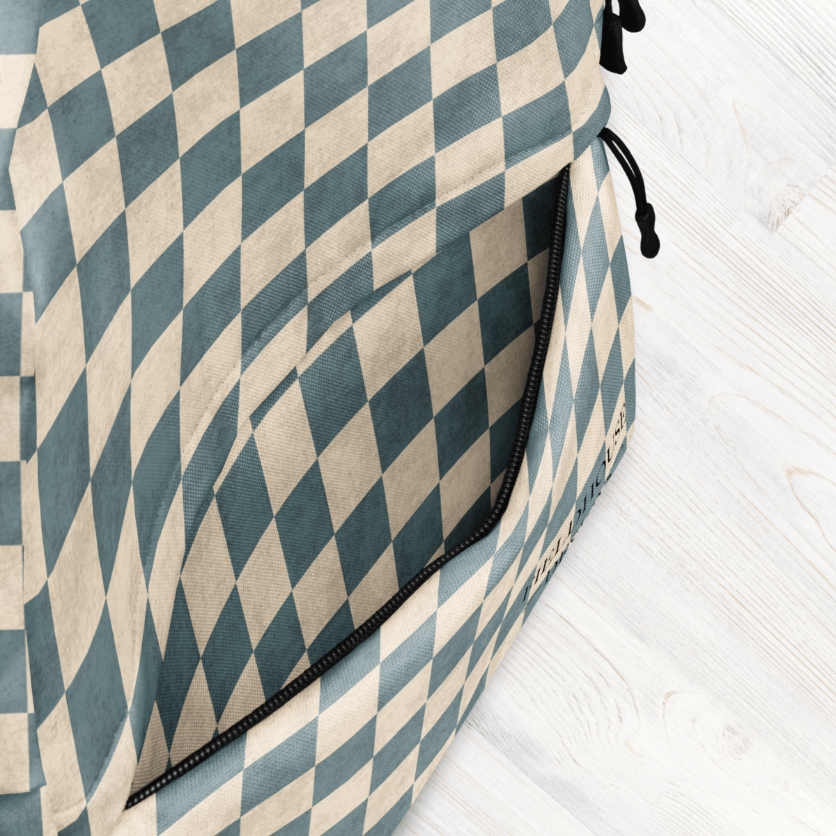 Dusty Blue Checkered backpack on a light wooden surface