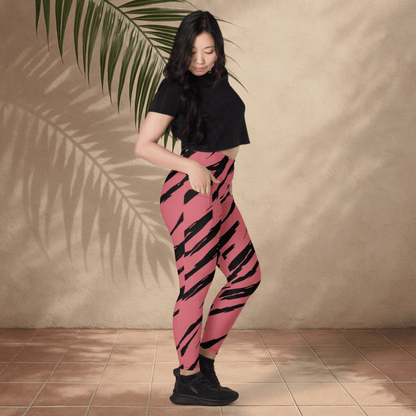Woman wearing pink leggings with black stripes against a beige wall.