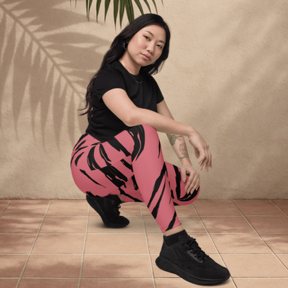 Person wearing a black t-shirt and pink pants with black tiger stripes, sitting on the floor with a leaf above.