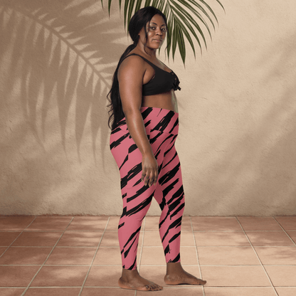 Person wearing pink and black tiger print leggings with a black top against a beige wall.