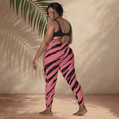 Woman wearing pink and black tiger-striped leggings against a beige wall.