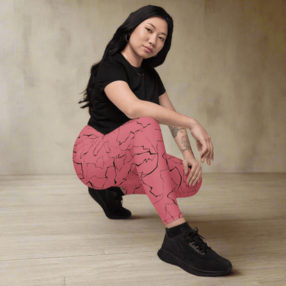 Person wearing pink patterned pants and black shoes on a neutral background
