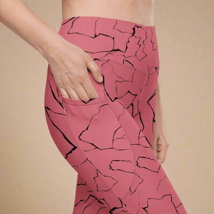 Pink leggings with black abstract pattern worn by a person on a beige background