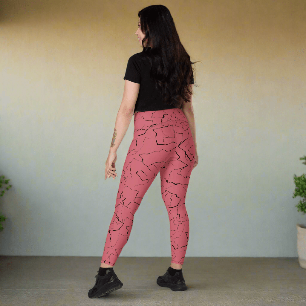 Woman wearing pink leggings with black abstract pattern on a neutral background