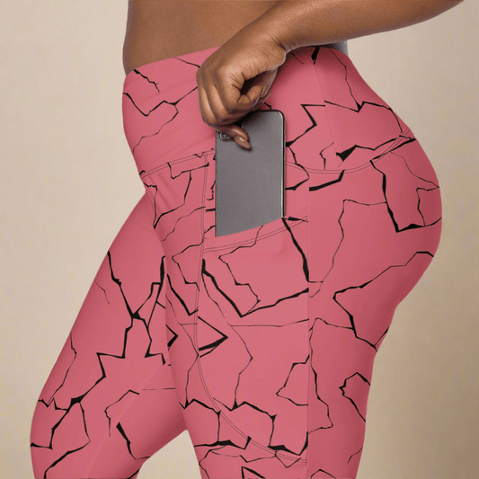 Pink leggings with black abstract pattern worn by a person, holding a phone.