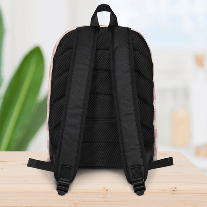 Backside of a backpack on a wooden surface with a blurred background