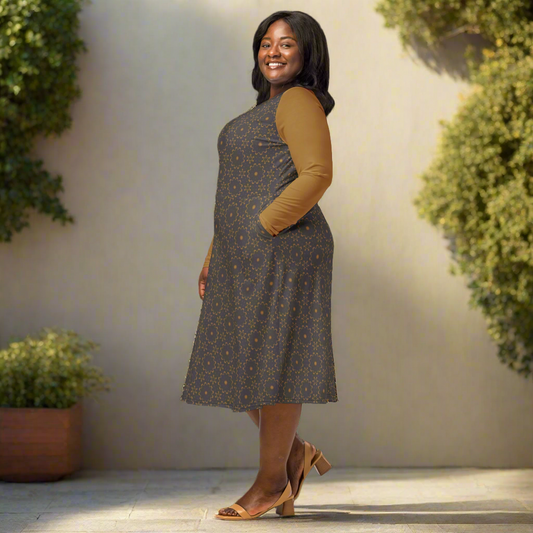 Woman wearing a patterned dress with a brown top and shoes on a neutral background
