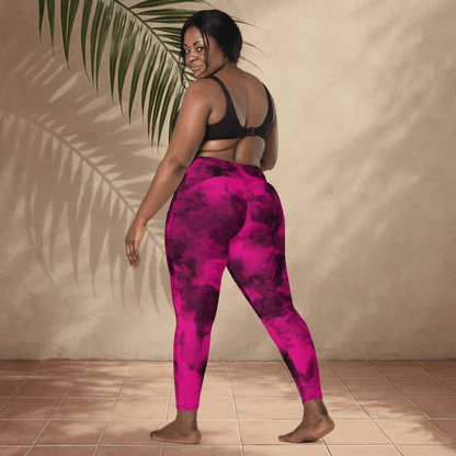 Person wearing pink and black tie-dye leggings standing against a beige wall.