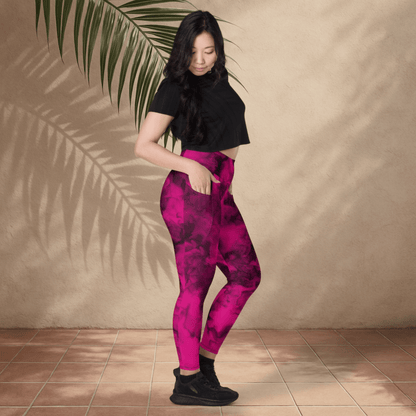 Woman wearing pink and black patterned leggings against a beige wall.