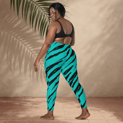 Woman wearing teal leggings with black tiger stripes against a beige wall.