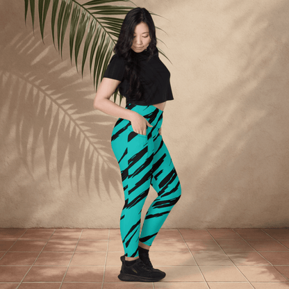 Woman wearing teal leggings with black stripes against a beige wall.
