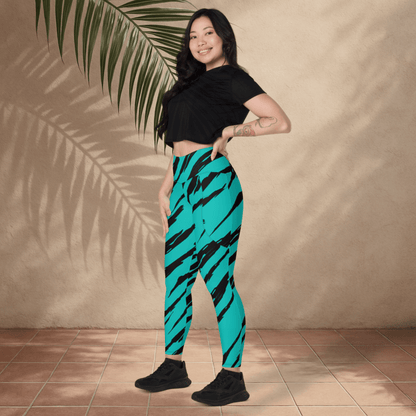 Woman wearing teal leggings with black stripes against a beige wall.