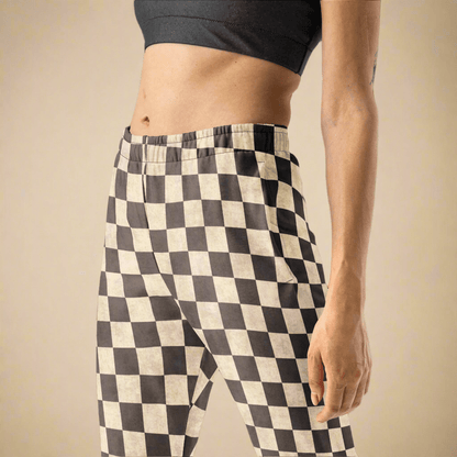 Person wearing grey and cream checkered pants on a beige background