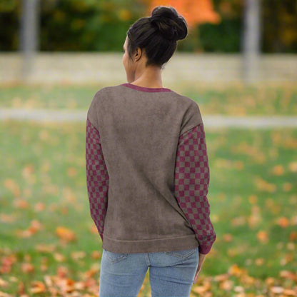 Person wearing an espresso  sweatshirt with checkered sleeves outdoors