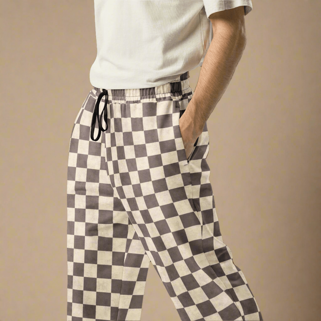 Person wearing checkered pants on a beige background