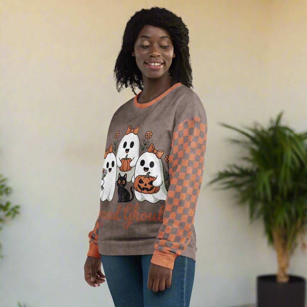 Woman wearing a Halloween-themed sweatshirt with ghosts and pumpkins on a neutral background