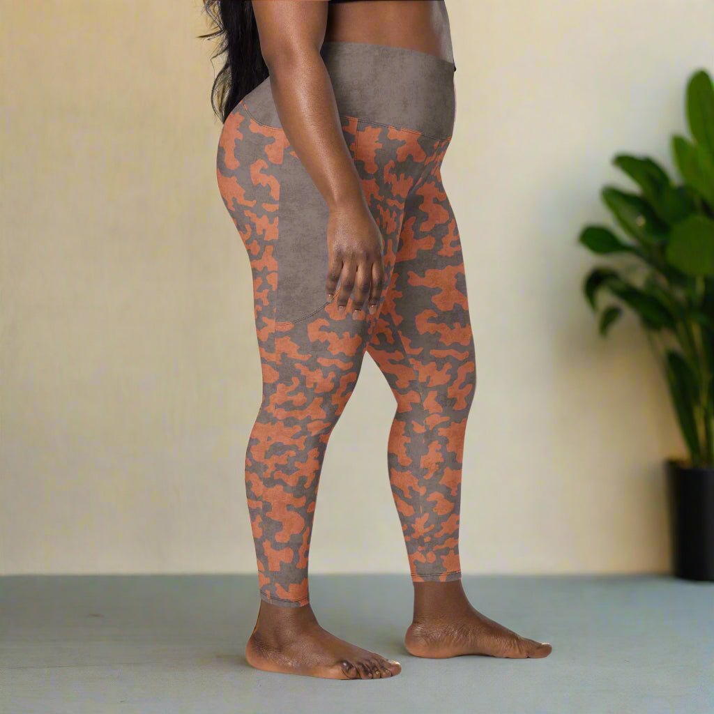 Person wearing camouflage leggings on a neutral background