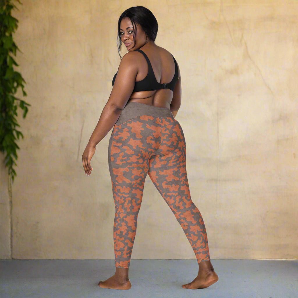 Woman wearing camouflage leggings on a neutral background