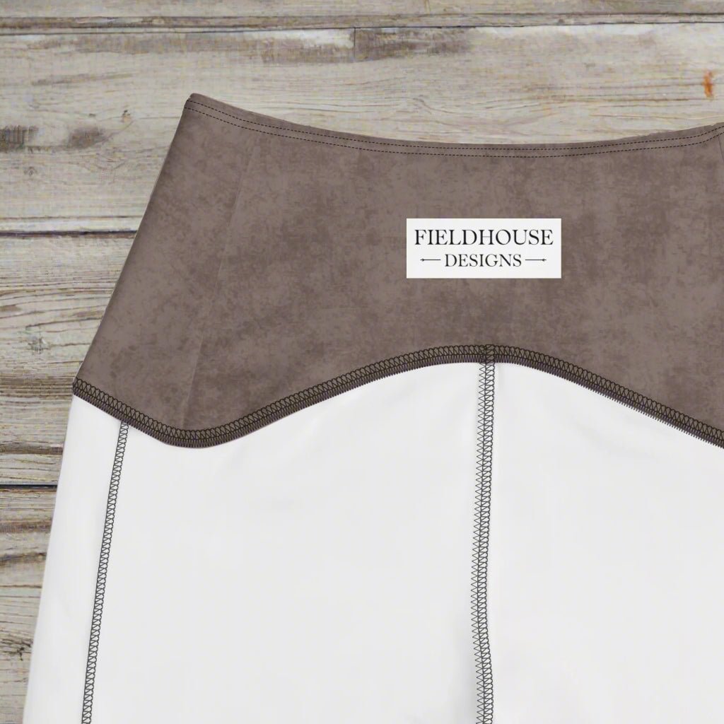Close-up of a brown garment with 'Fieldhouse Designs' label on a wood background