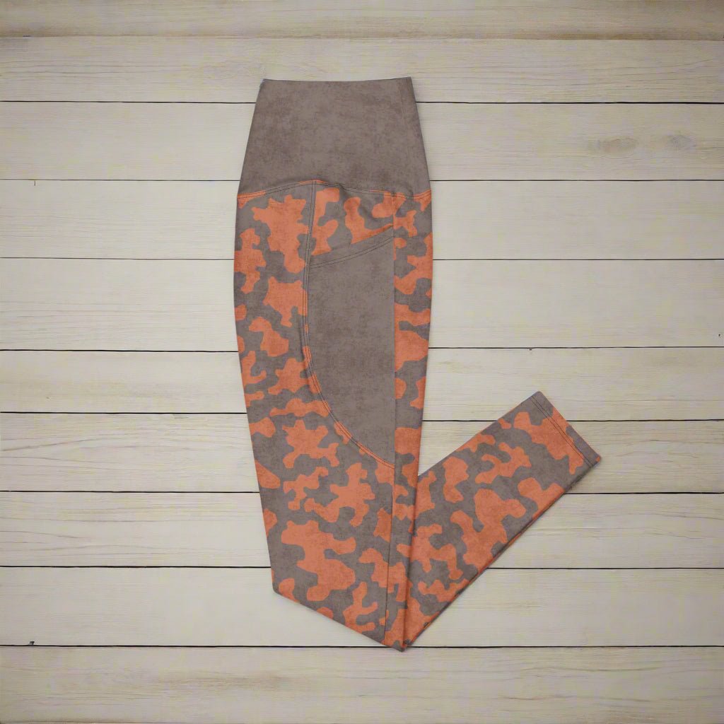 Brown and orange camouflage leggings on a wooden surface