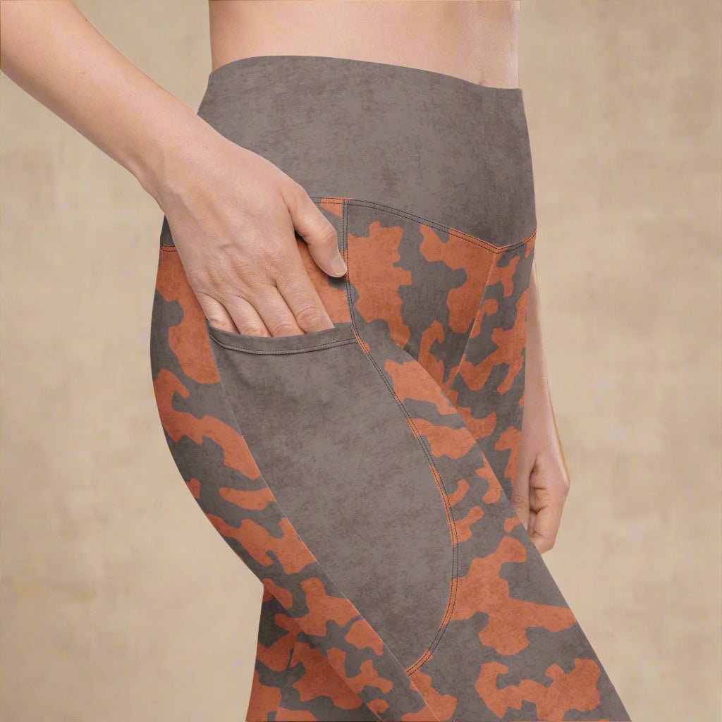 Gray and orange camouflage pants with a pocket detail on a beige background