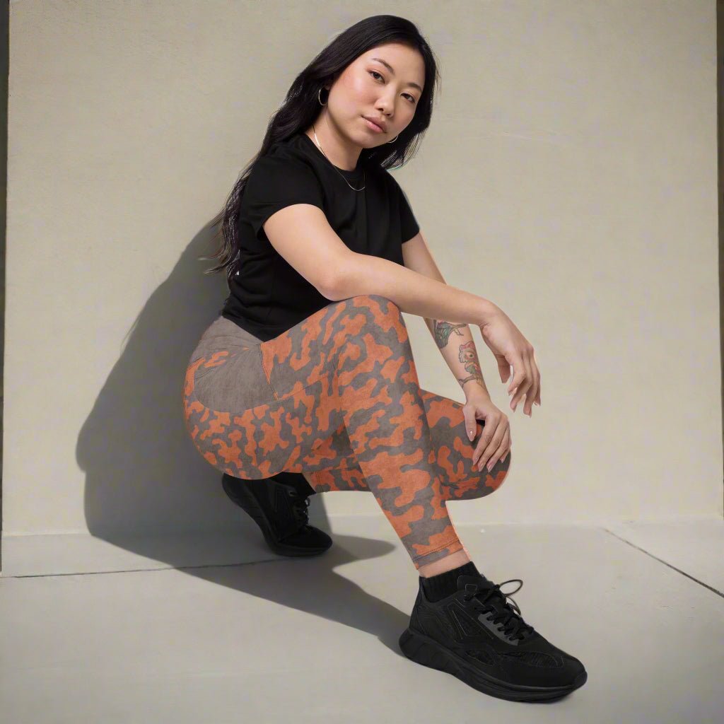 Person wearing camouflage leggings and black shoes on a neutral background