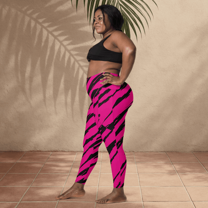 Woman wearing pink and black tiger print leggings against a beige wall.