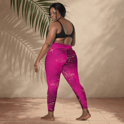 Woman wearing pink leggings with gold glitter patterns, standing against a beige wall.