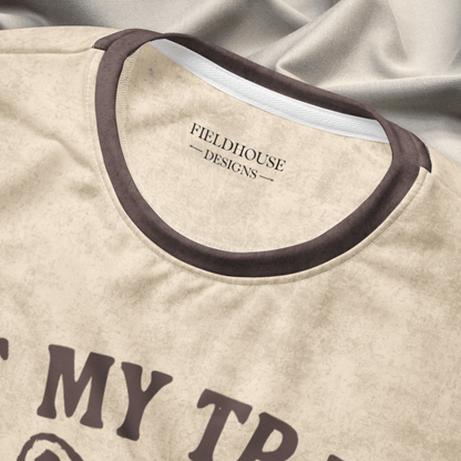 collar close up of Beige crewneck sweatshirt with espresso checkered sleeves. Featuring a raccoon reading a book graphic and text 'Not my trash, not my dumpster' 