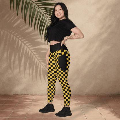 Woman wearing black and yellow checkered pants with a plain background