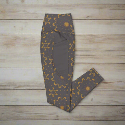 Dark gray leggings with gold star pattern on a wood background