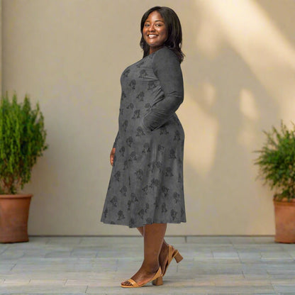 Woman wearing a gray floral dress standing in front of a beige wall with plants.